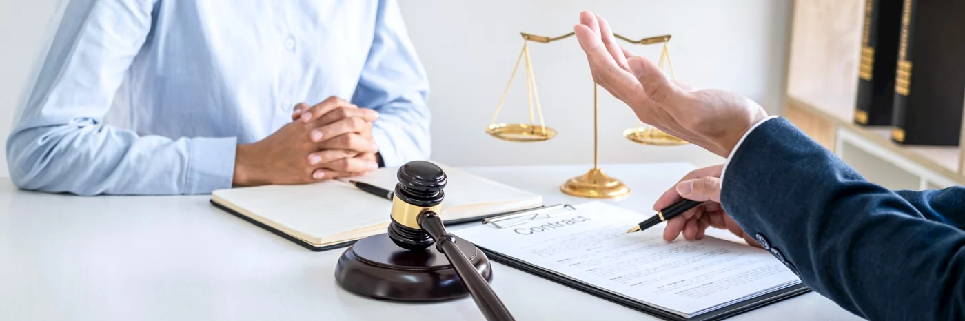 Client and lawyer discussing documents at a desk
