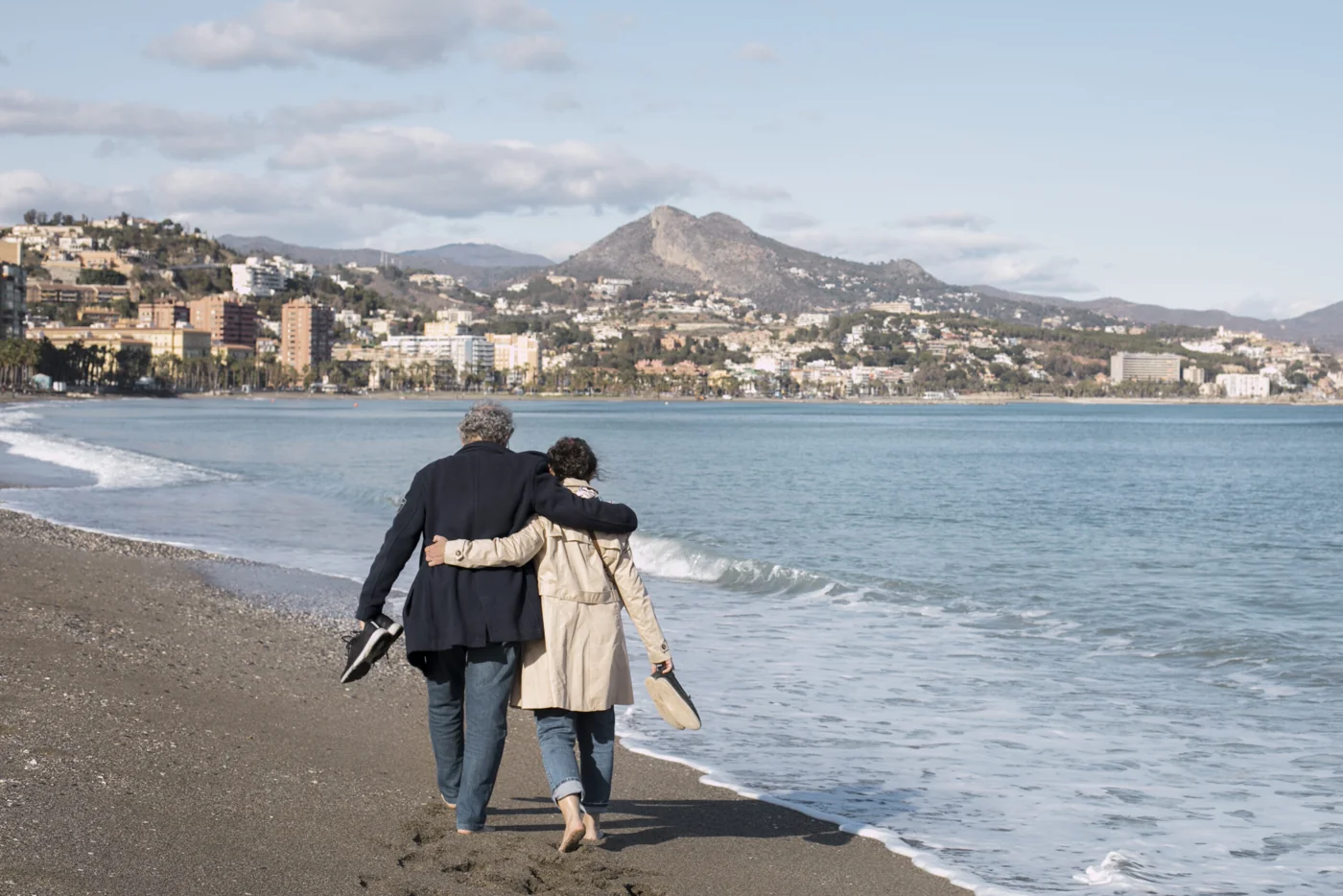 Older couple walking together on a beach