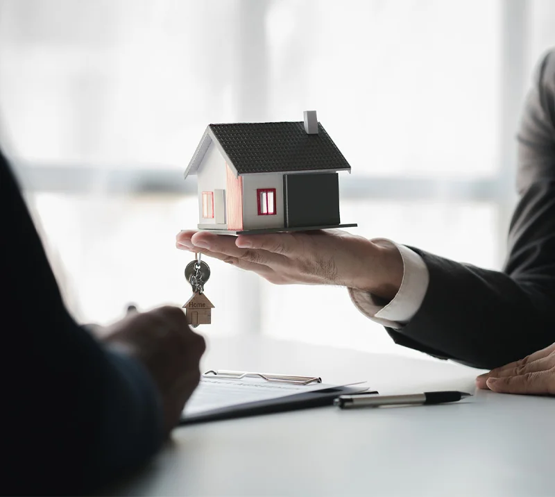 House model being handed over during a property transaction