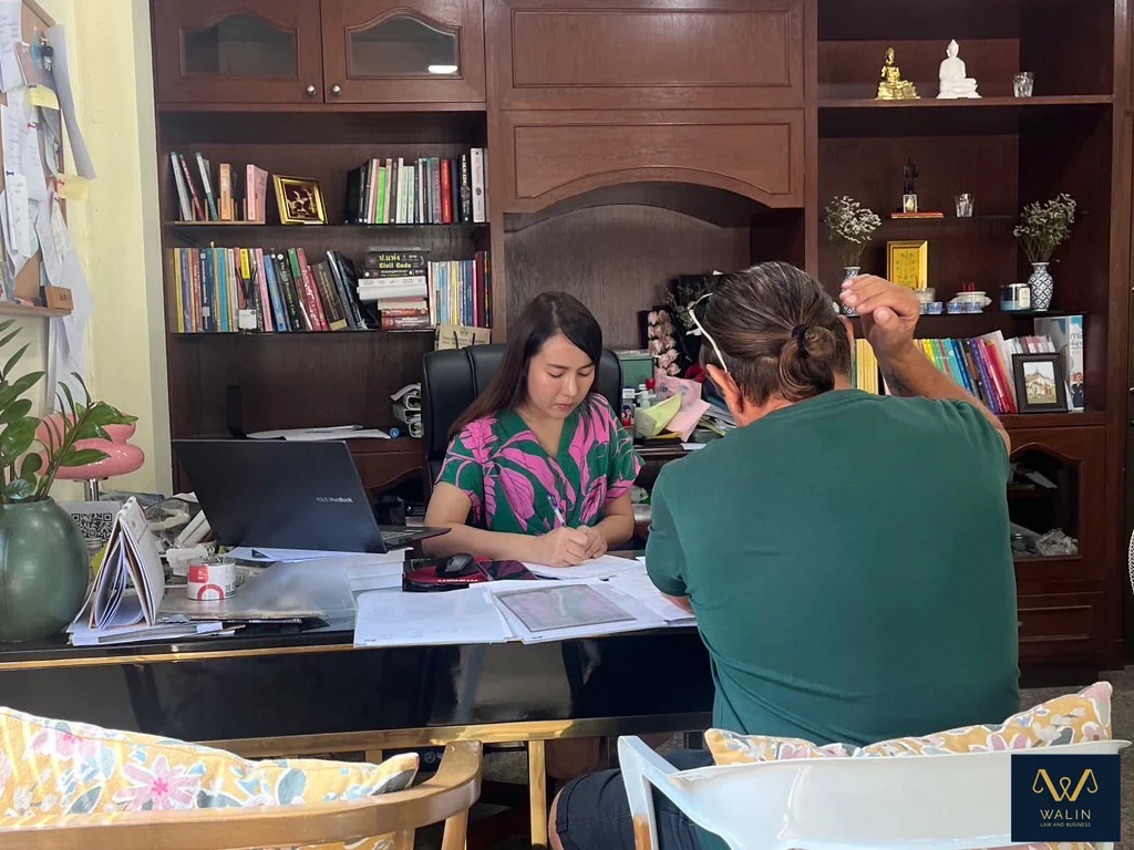 An office consultation with documents laid out for discussion.